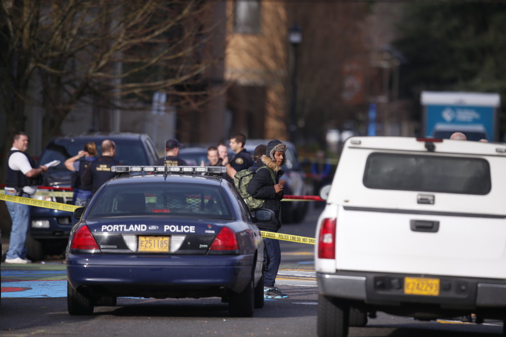 Police gather where a shooting occurred near Rosemary Anderson High School in Portland, Ore., on Friday.