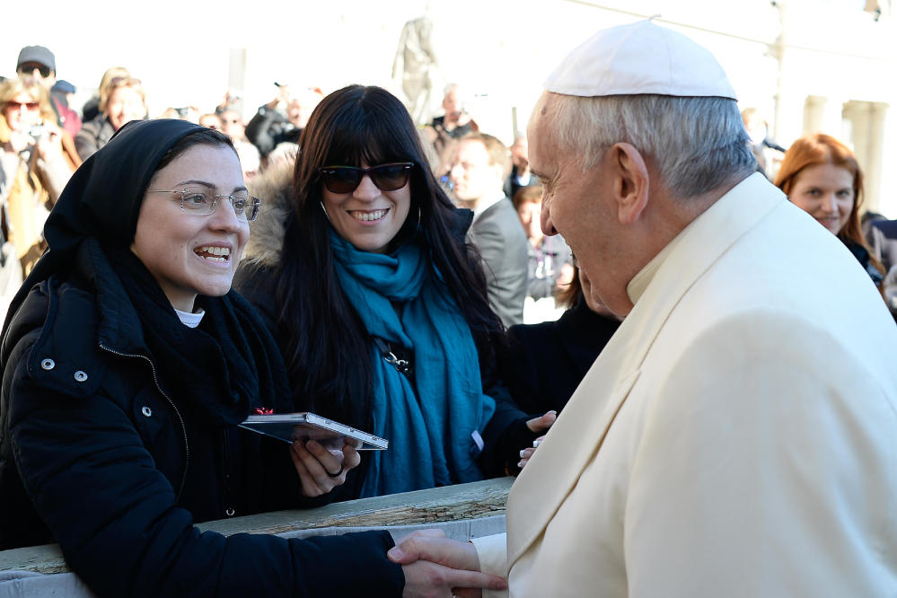 Pope Francis greets Sister Cristina Scuccia as she gives him one of her CDs at the end of his weekly general audience at the Vatican on Wednesday. After winning the Voice of Italy singing contest, the Ursuline nun launched her first album “Sister Cristina” last month.