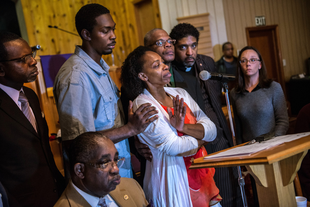 Claudia Lacy, center, cries as she thanks the people who showed up Dec. 1 at the First Baptist Church in Bladenboro, N.C., to hear the Rev. Dr. William Barber II, president of the North Carolina State Conference of the NAACP, talk about the investigation of her son’s death. Lennon Lacy, 17, was found hanging from a swing set in the middle of a trailer park in late August.