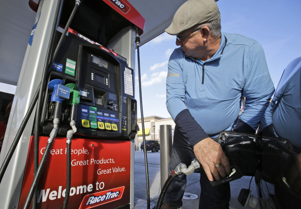 Eduardo Palacios-Paez, of Miami, pumps gas at a RaceTrac gasoline station in Hialeah, Fla. Motorists are now seeing prices under $3 a gallon for the first time in four years, which means that gas stations are paying less for the fuel, too. The Associated Press
