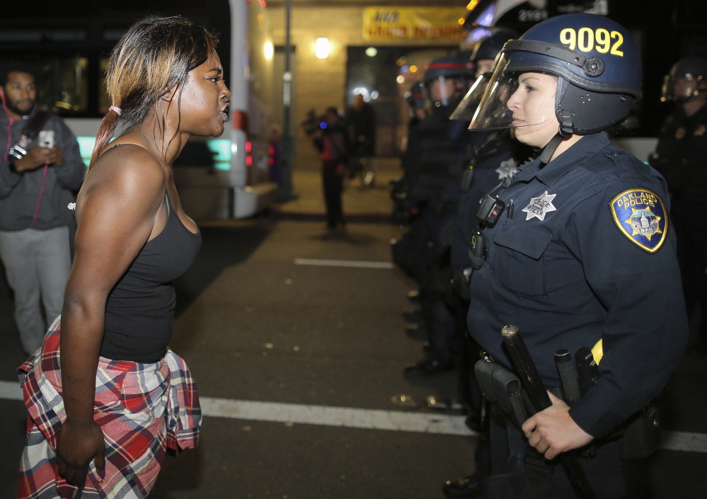 Amanda Ashe of Oakland, left, faces off with police in Emeryville, California, following the Nov. 25 grand jury decision in the shooting of Michael Brown in Ferguson, Mo.