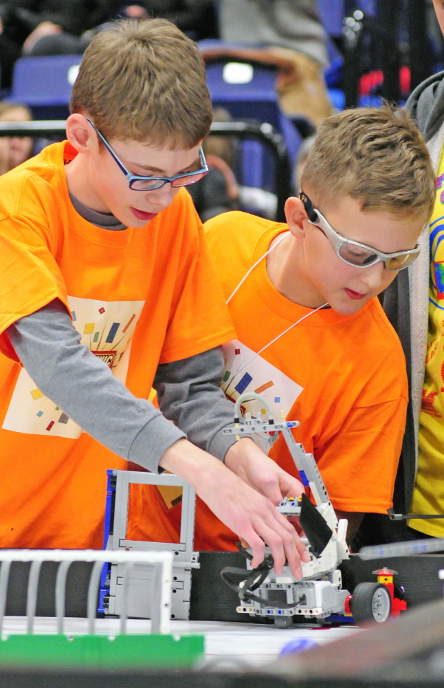 Trafton Gray, left, and Forest Holbrook set up the TechnicFreaks’ robot on Saturday in the Augusta Civic Center. The TechnicFreaks are the first team from Hall-Dale schools in Hallowell to test their robotics in the Maine FIRST LEGO League Championship.