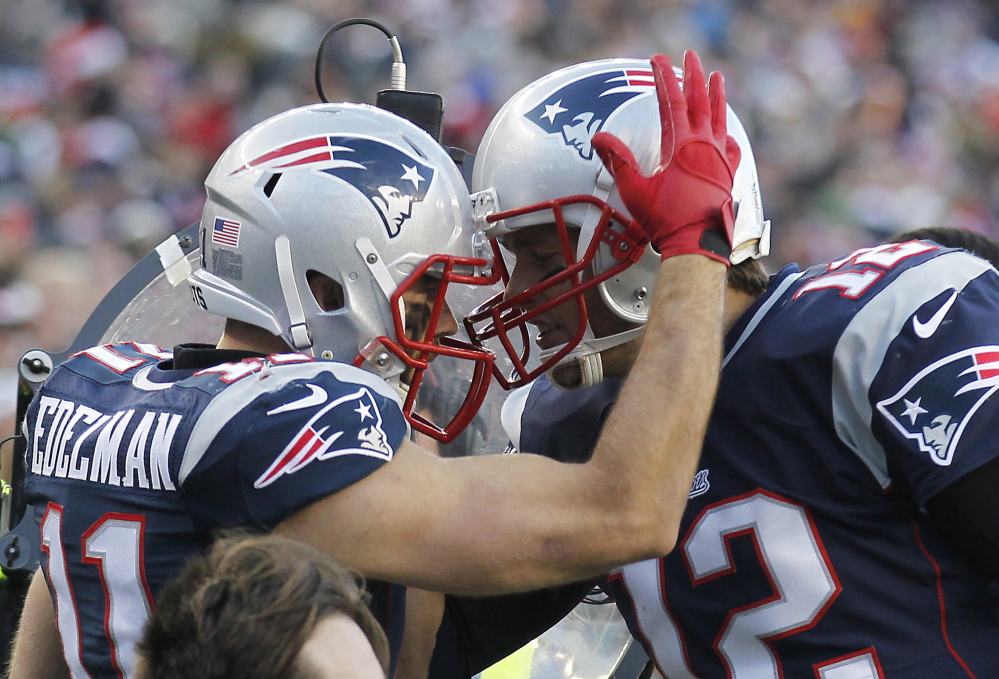 New England Patriots wide receiver Julian Edelman, left, celebrates with quarterback Tom Brady after scoring a touchdown during the third quarter against the Miami Dolphins at Gillette Stadium on Sunday.