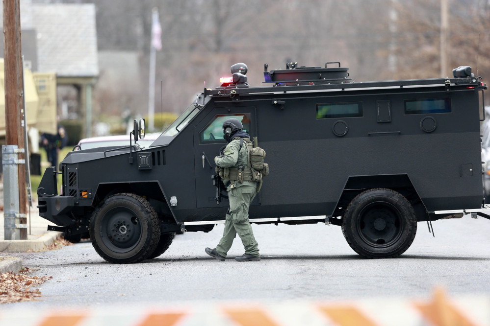 Police move near the scene of a shooting Monday in Souderton, Pa. Police surrounded a home in Souderton, outside Philadelphia, where the suspect is believed to have barricaded himself after shootings at multiple homes.