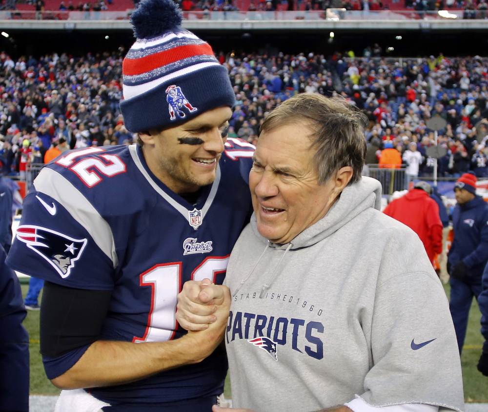 Tom Brady, left, and Bill Belichick celebrate after the Patriots’ 41-13 win over Miami that gave New England its 11th AFC East title in 12 seasons.
Reuters/Winslow Townson
