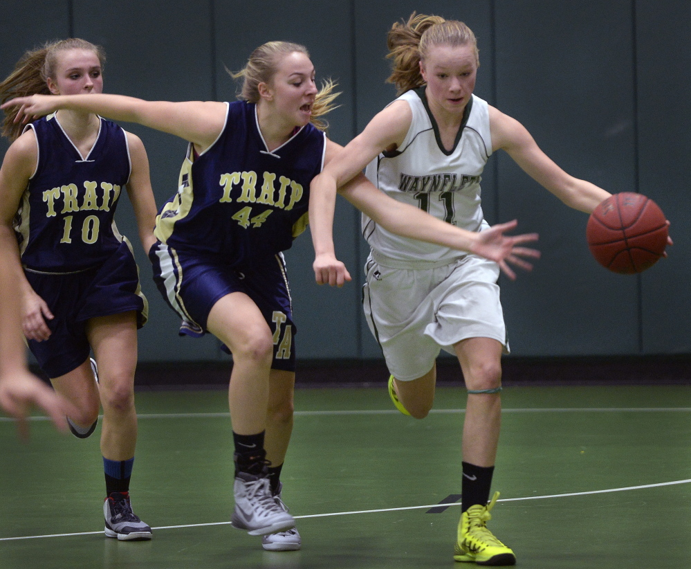 Waynflete’s Lydia Giguere dribbles away from Traip Academy’s Marina Casey in Tuesday night’s girls’ basketball game in Portland. Giguere had nine points in Waynflete’s 63-32 win.