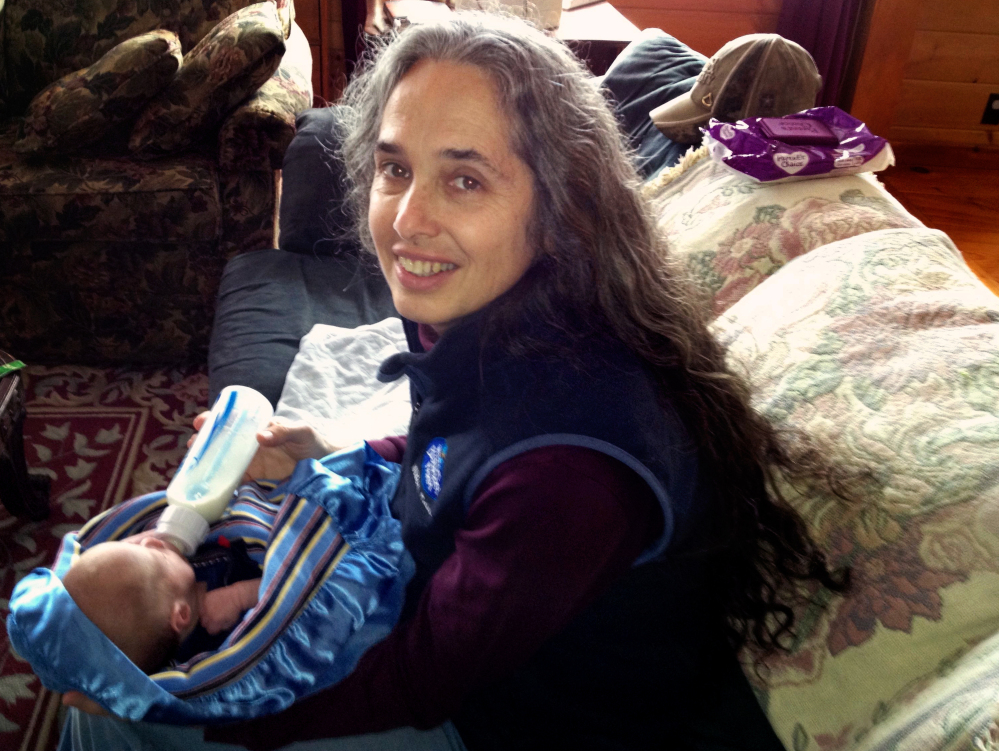 Jan Collins of Wilton, Maine, is shown holding her infant grandson, Ethan Henderson. She called a hotline before his birth to register fears that her son would hurt his children. Ethan’s subsequent death raised questions about how the state handled warning signs.