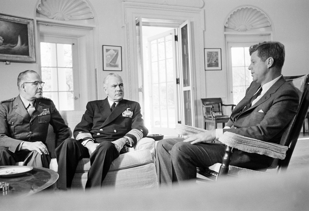 President John F. Kennedy poses in his White House office with Gen. David Shoup, left, Marine Corps Commandant, and Adm. George Anderson, Chief of U.S. Naval Operations, Oct. 29, 1962.  The chiefs met with the president to review the present situation in Cuba and operation of the U.S. naval blockade.  (AP Photo/William J. Smith)