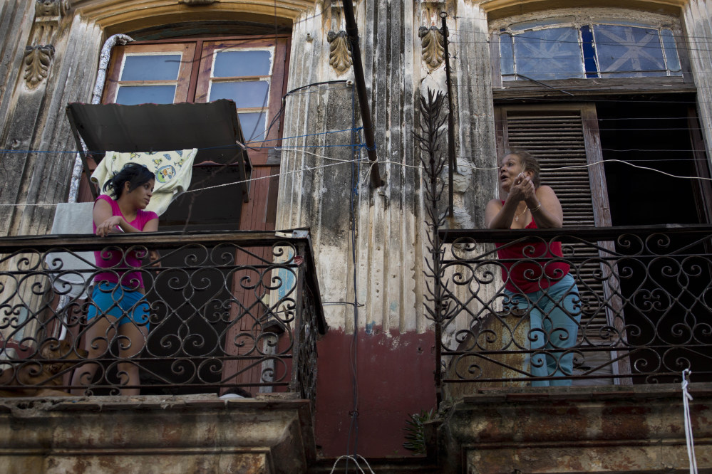 Two women talk across their balconies in Old Havana, Cuba, on Thursday. After a half-century of pointing fingers, a historic shift between the U.S. and Cuba could revitalize the flow of money and people between the two nations.