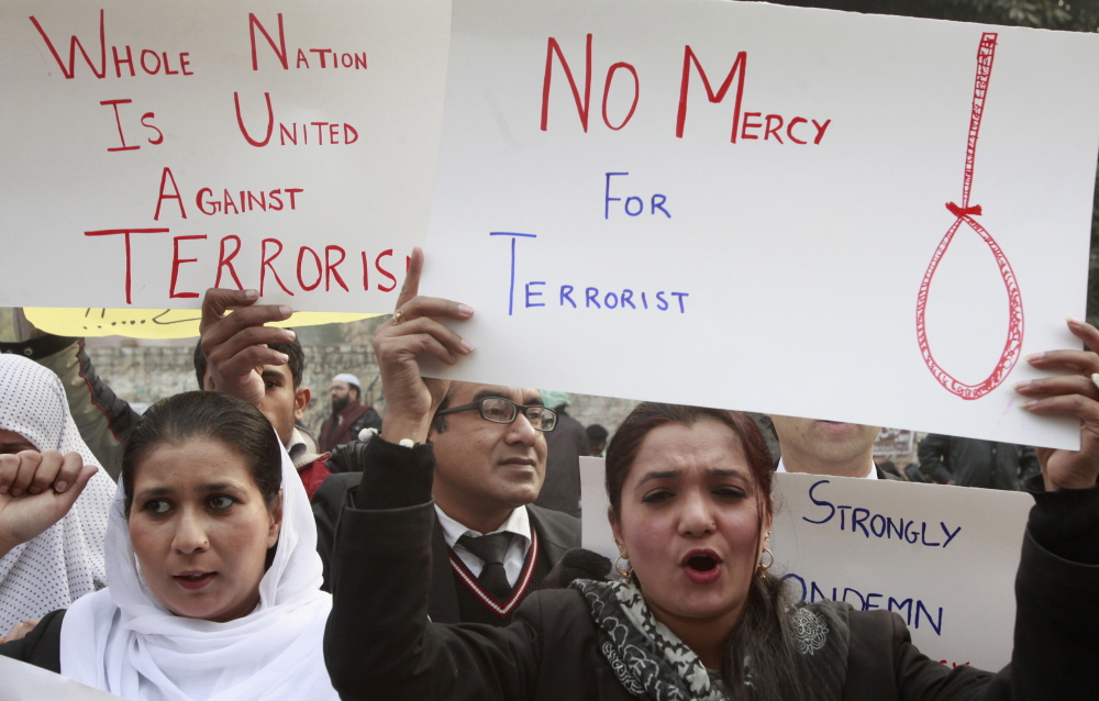 Civil society activists hold placards as they chant slogans condemning the attack on the Army Public School by Pakistan Taliban gunmen, during a rally in Lahore, Pakistan, on Thursday. The government and courts are moving toward executing convicted terrorists.