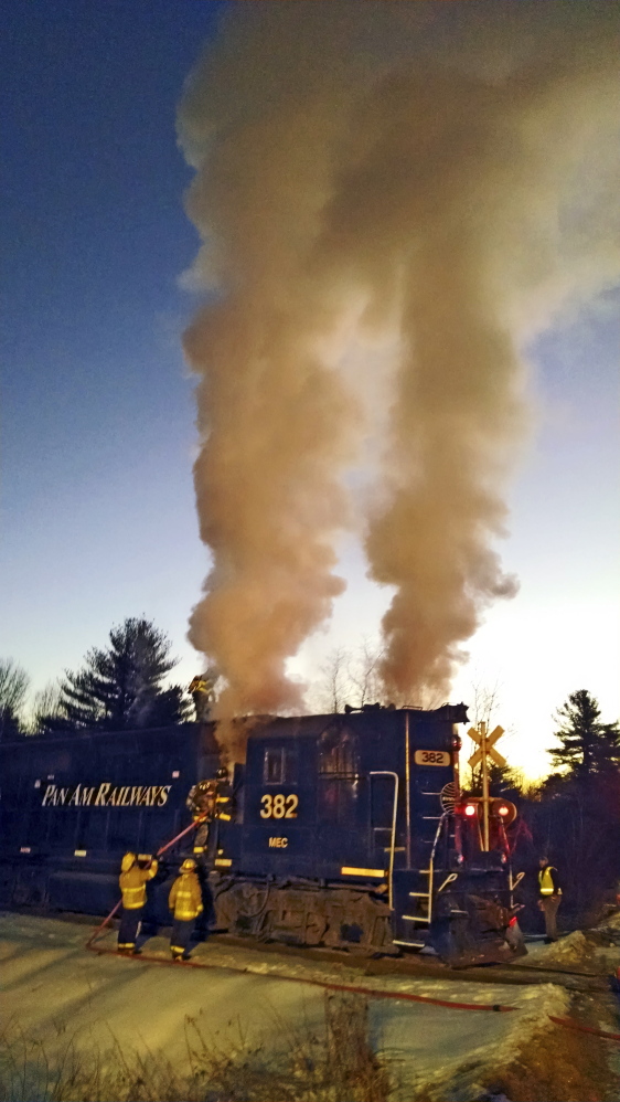 Monmouth firefighters work to extinguish a locomotive fire on a Pan Am Railways train Saturday morning near Berry Road in Monmouth.