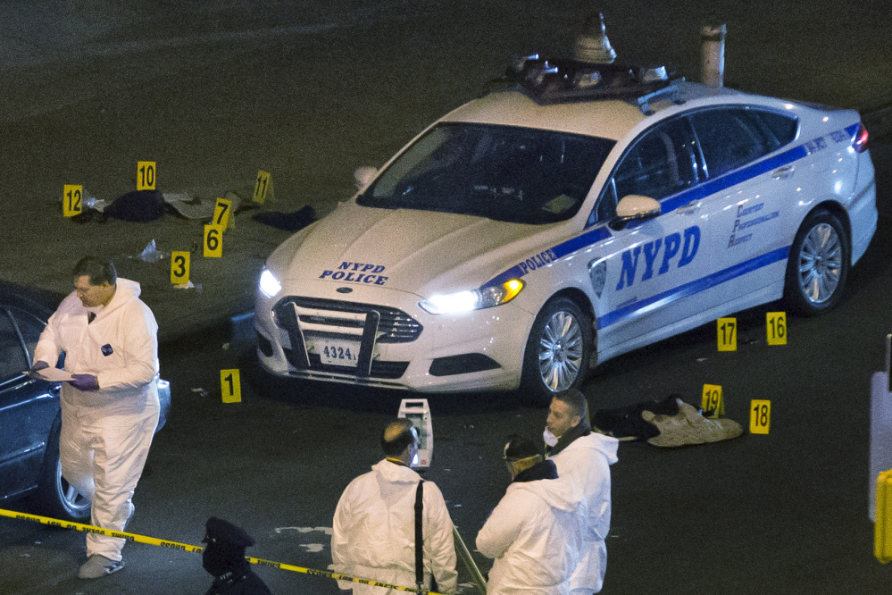 Bulletproof vests lie on each side of an NYPD patrol car as investigators work at the scene where two NYPD officers were shot in the Bedford-Stuyvesant neighborhood of the Brooklyn borough of New York on Saturday.