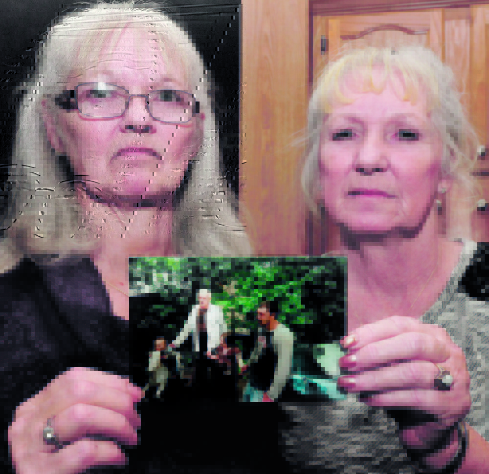 Joan Cuares, left, and Debbie DeYoung hold a photograph that shows their brother Dana Kitchin on Thursday. Kitchin, who lived in Waterville, was found dead Dec. 12 in the Kennebec County Correctional Facility in Augusta.