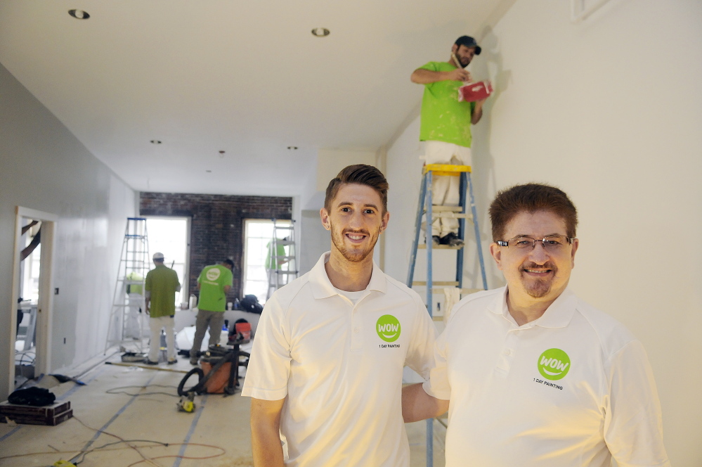Ryan Guerrette and his father, William, at the Augusta apartment building their family owns on Thursday. The men have opened a Wow 1 Day Painting franchise.