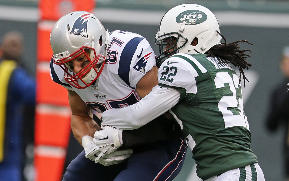 Marcus Williams of the Jets tackles New England’s Rob Gronkowski during the second half Sunday at East Rutherford, N.J.