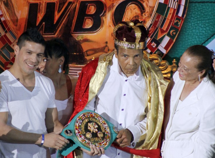 Former heavyweight boxing champion Muhammad Ali is crowned “King of Boxing” while accompanied by his wife, Lonnie, right, and Argentine boxer Sergio Martinez during the 50th convention of the World Boxing Council in Cancun, Mexico.