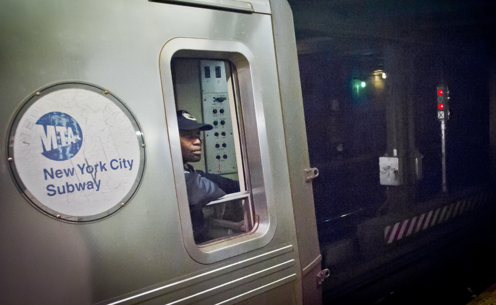 A Metropolitan Transit Authority subway train operator in New York waits for red-light signal to turn green. The signal is controlled by a manual subway interlocking switch and signal system that is eight decades old.