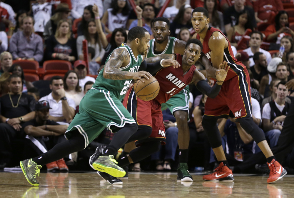 Boston guard Jameer Nelson drives against Miami’s guard Mario Chalmers (15) on Sunday in Miami. Nelson played his first game with the Celtics, who lost to the Heat 100-84.