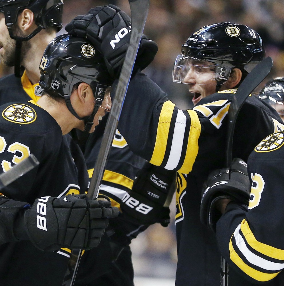 Loui Eriksson, right, celebrates with teammate Chris Kelly (23) after scoring in overtime to give the Boston Bruins a 4-3 win over the Buffalo Sabres on Sunday in Boston. The Bruins scored late in the third to force OT.