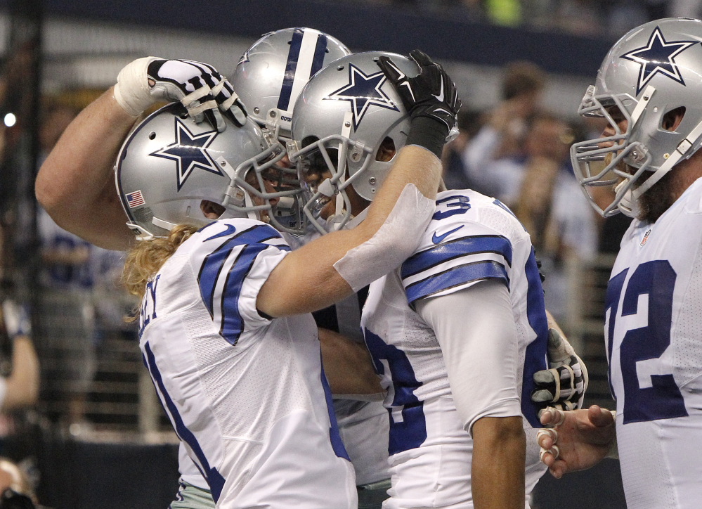 Cowboys wide receiver Cole Beasley, left, is congratulated by his teammates after catching a touchdown pass in the first quarter Sunday against the Indianapolis Colts. Dallas built a 35-0 halftime lead and earned its first playoff berth since 2009 with a 42-7 win.
