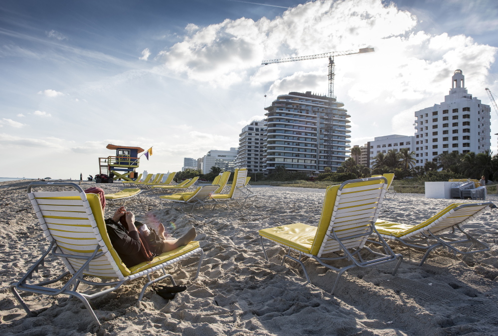 A day at the beach may include the hustle and bustle of construction as developers create and cash in for a demand of high-end Miami Beach properties – some of which foreigners buy as investments and never set foot in.