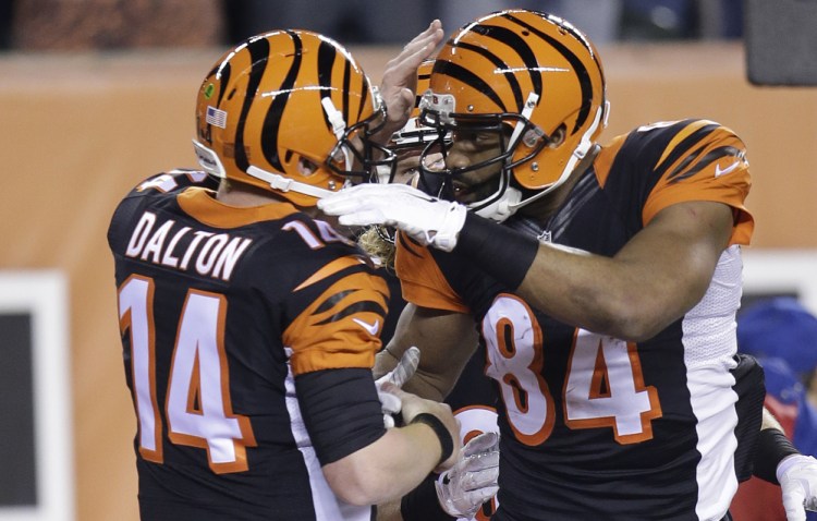 Cincinnati Bengals tight end Jermaine Gresham (84) is congratulated by quarterback Andy Dalton after Gresham made a 2-yard touchdown reception during the first half of Monday night's game against the Denver Broncos. The Bengals won to clinch a playoff berth.