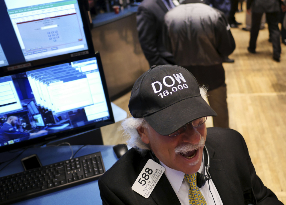 Peter Tuchman wears a “DOW 18,000” hat on the floor of the New York Stock Exchange on Tuesday, when U.S. stocks pushed farther into record territory.
