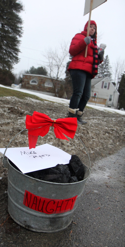 Strikers put a bucket of coal and a “note from Santa” on the sidewalk near the home of FairPoint’s Maine president.