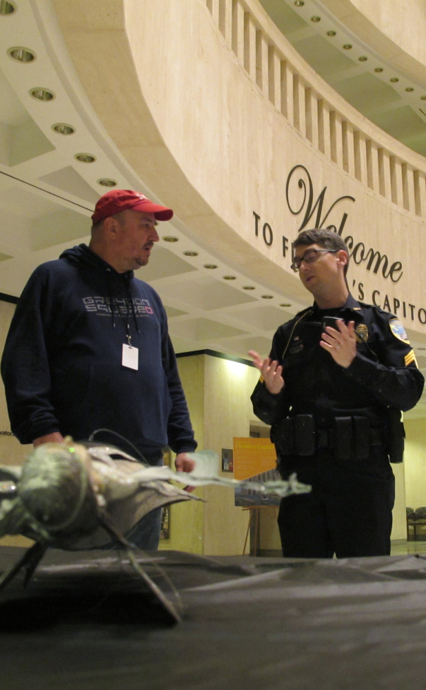 John Porgal, regional director of the American Atheists, talks with a police officer in Tallahassee, Fla.