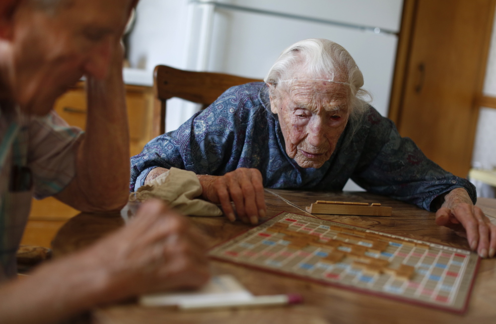 Anna Stoehr plays Scrabble at her home in Pottsdam, Minn., with her son, Harlan. Stoehr had recently joined Facebook, which sent her a bouquet of 114 flowers on her birthday.