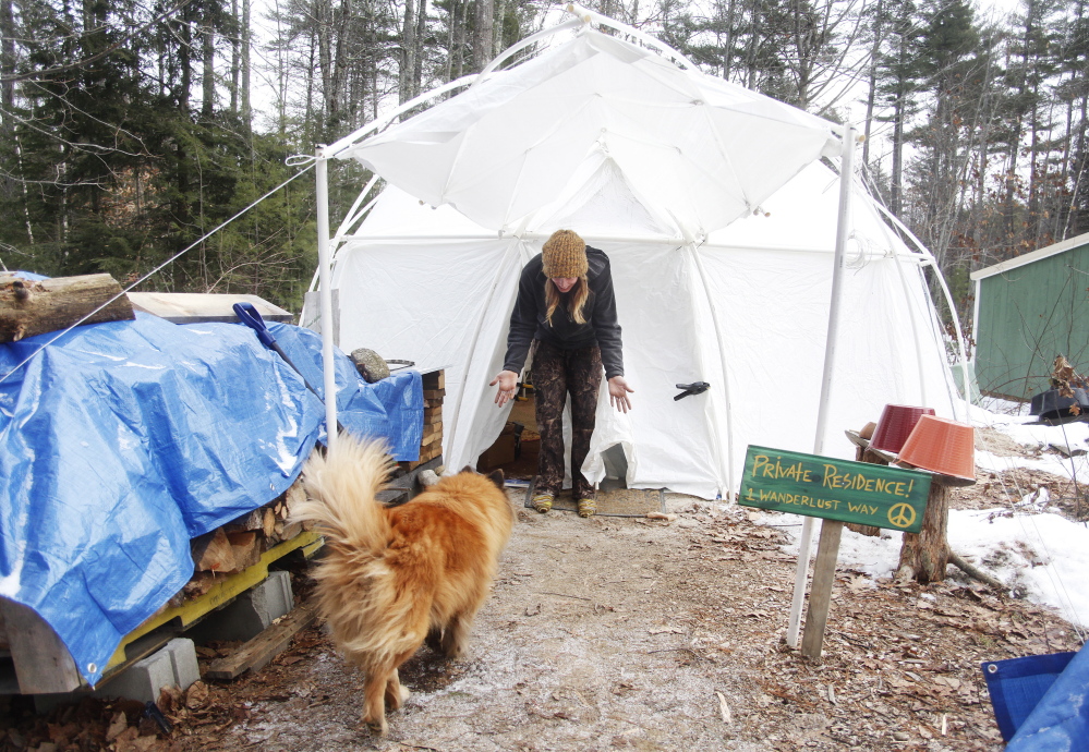 Kate Wentworth, 26, greets her dog, Bruiser, an 8-year-old chow/Australian shepherd cross, at the door of her yurt. She is living on a homestead in York County for the winter in an attempt to experience the way her ancestors lived.