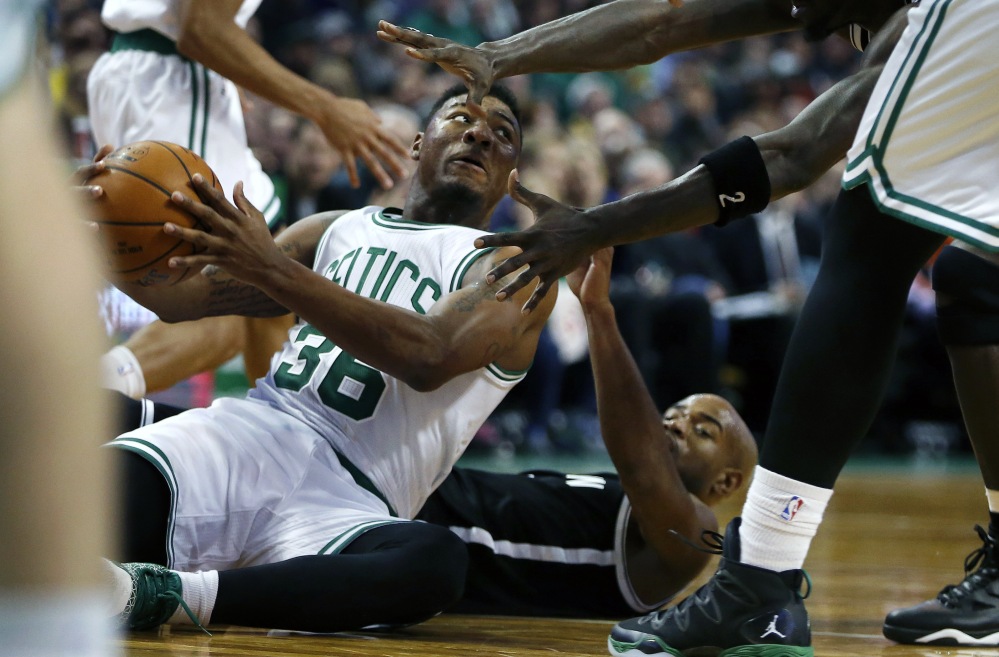 The Celtics’ Marcus Smart looks to pass after winning the battle for a loose ball with Brooklyn’s Jarrett Jack, bottom right, in the third quarter of Friday’s afternoon game in Boston. The Nets won, 109-107, as Jack scored 27 points.