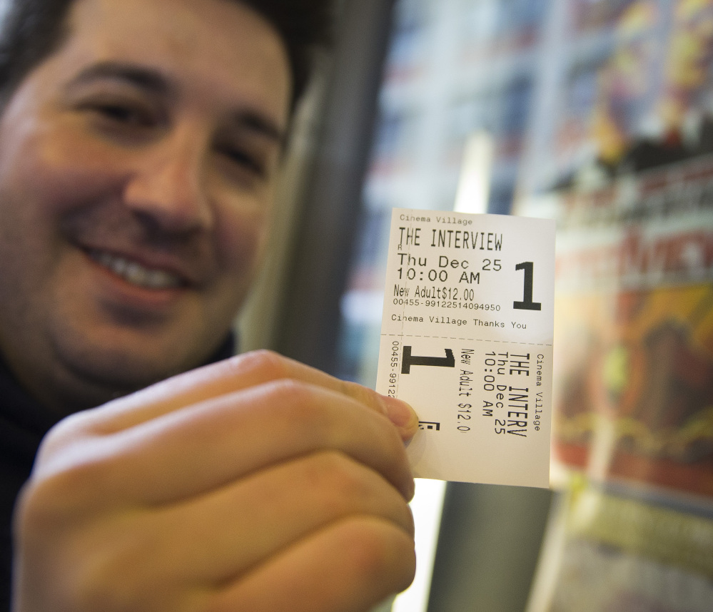 Derek Karpel holds his ticket to a screening of “The Interview” at Cinema Village movie theater in New York on Thursday. The film raked in just over $1 million in ticket sales.