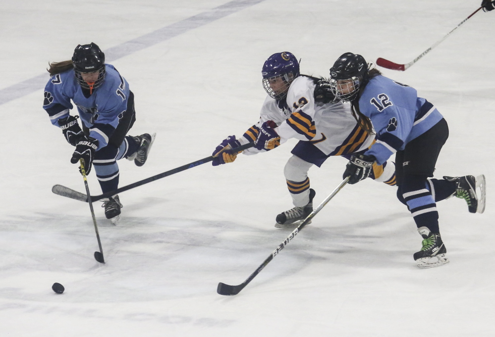 PORTLAND, ME - DECEMBER 26: York players Sophia Blanchard, left, and Kayla Kelly, right, try to beat Cheverus player Jill Hannigan to the puck at the Portland Ice Arena in Portland, ME on Friday, December 26, 2014. (Photo by Whitney Hayward/Staff Photographer)