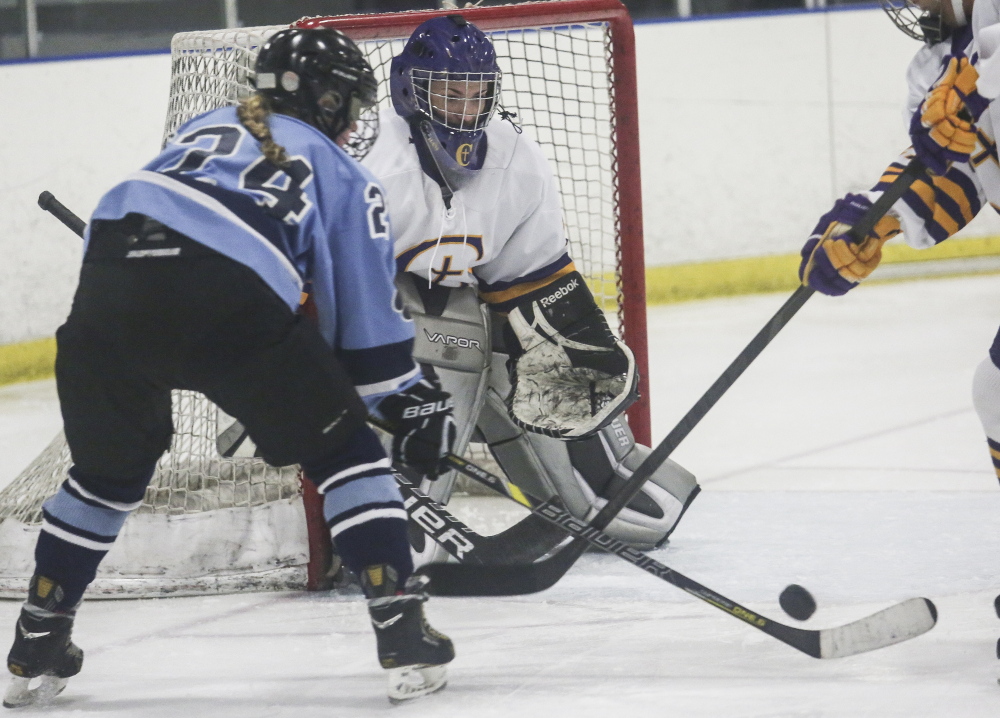 Cheverus goalie Taylor Courtois, who finished with 25 saves, sets up to stop a scoring bid by Katherine Bertolini of York during York’s 4-3 victory Friday at the Portland Ice Arena.
