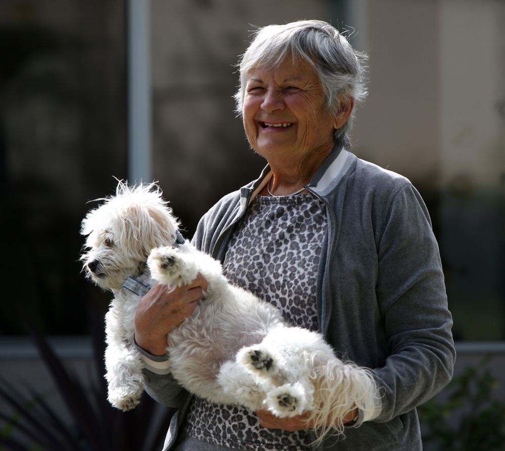 Jovanka Radivojevic, 78, a retired physician, holds her 5-year-old dog Sugar, who survived a recent coyote attack in front of Radivojevic’s home in Seal Beach, Calif.