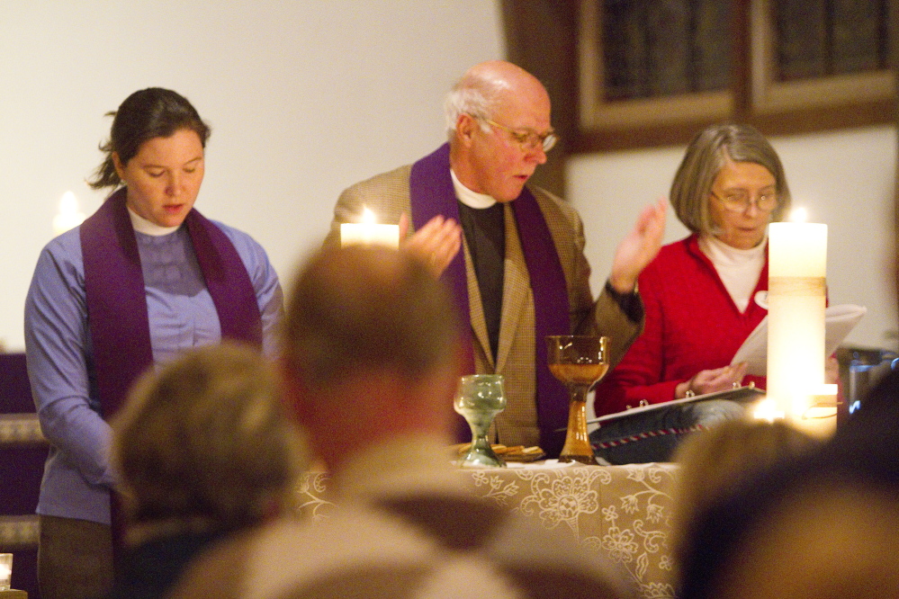 Deacon Kelly Moughty, the Rev. Timothy Boggs and Karen Rea, chalice bearer, stand at the altar during communion at St. Alban’s Episcopal Church in Cape Elizabeth during a Celtic Eventide service on Dec. 7.
