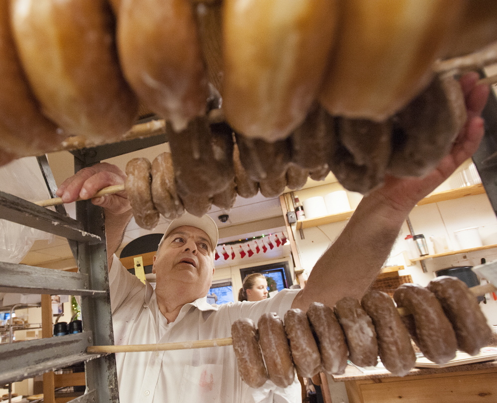 Daryl Buck, 66, removes glazed doughnuts from a rack at Hillman’s Bakery in Fairfield on Tuesday morning. “Since I was 12 years old, this has been a big part of my identity,” he said.