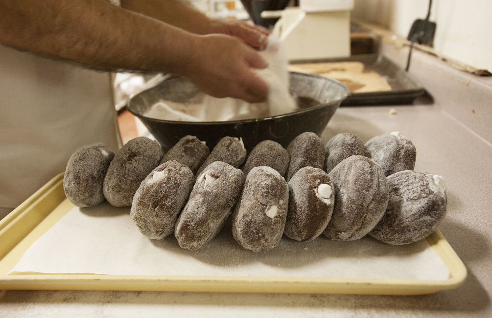 Daryl Buck rolls doughnuts in sugar at Hillman’s Bakery in Fairfield on Tuesday morning. Wednesday was Buck’s last day making doughnuts and pastries at Hillman’s.