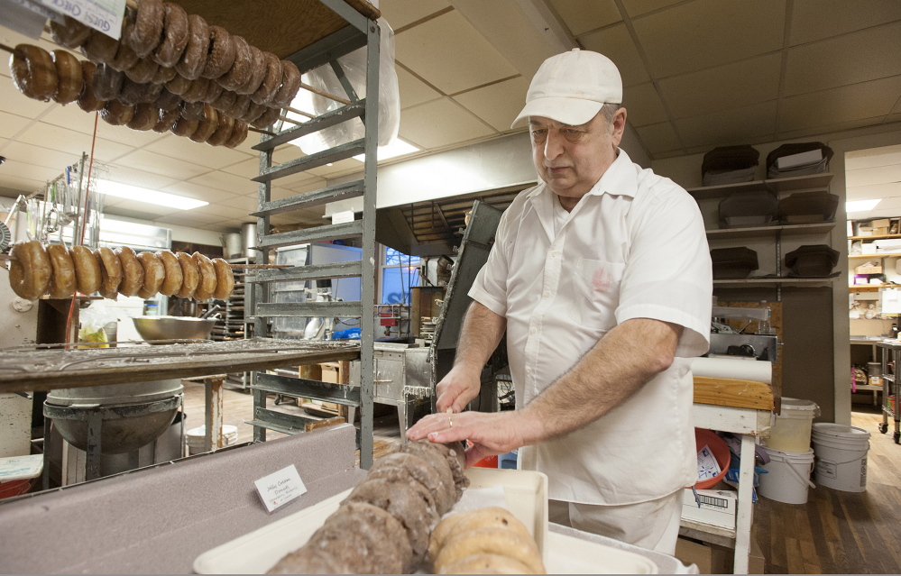 Daryl Buck removes glazed doughnuts from a rack at Hillman’s Bakery in Fairfield on Tuesday morning. Buck has worked on and off at bakeries since he was in high school. Wednesday marked the end of a career for Buck, who is retiring.