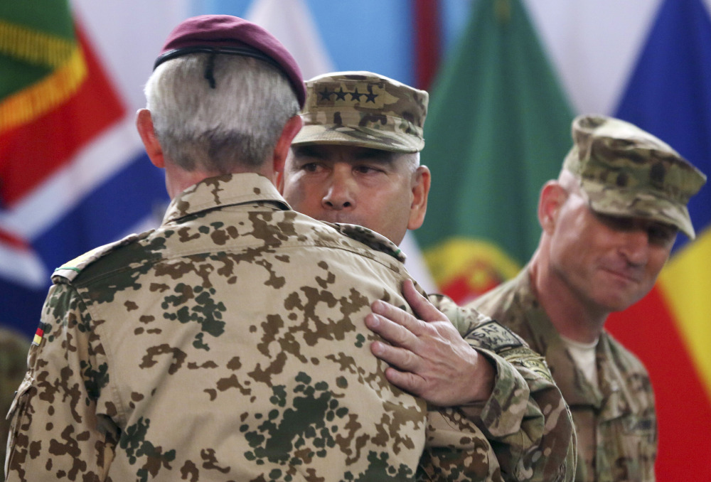 Commander of the International Security Assistance Force, Gen. John Campbell, center, hugs ISAF Gen. Hans-Lothar Domrose, as Command Sgt. Maj. Delbert Byers watches them during a ceremony at the ISAF headquarters in Kabul, Afghanistan, on Sunday. 