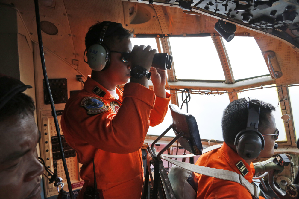 The crew of an Indonesian air force plane scans the horizon during a search for the missing AirAsia flight 8501 over the waters of the Karimata Strait in Indonesia on Monday. 