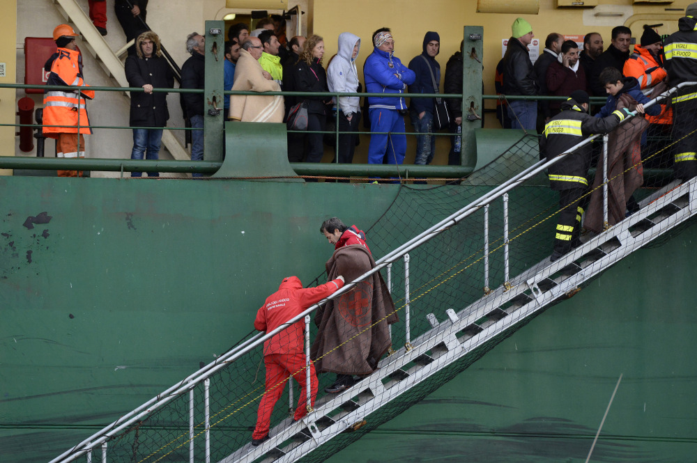 Passengers and crew members of the Norman Atlantic, which caught fire in the Adriatic Sea, disembark from a ship in southern Italy on Monday.