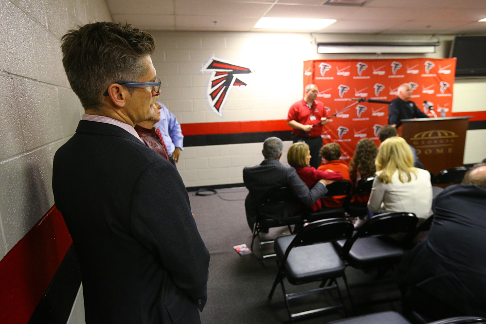 Atlanta Falcons general manager Thomas Dimitroff, left, listens to coach Mike Smith during a news conference after the Carolina Panthers defeated the Falcons 34-3 Sunday in Atlanta.