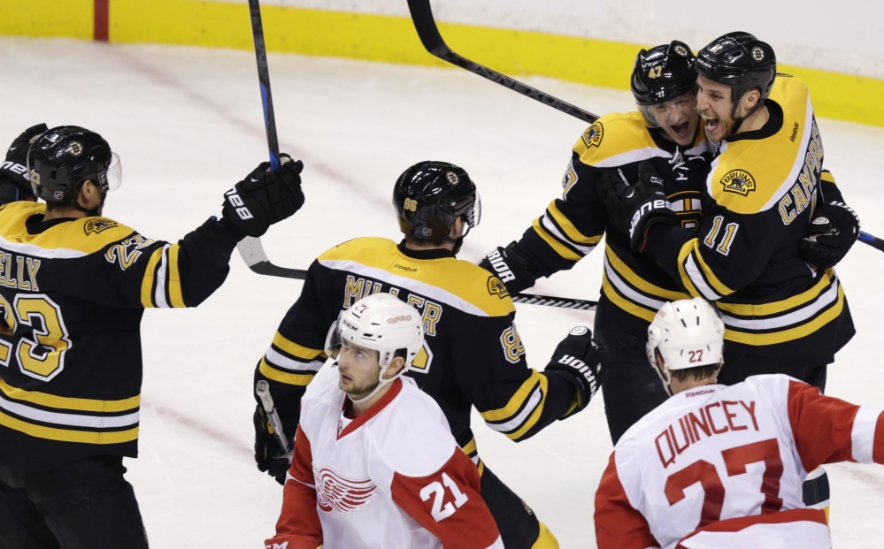 Boston Bruins center Gregory Campbell, right, is congratulated by teammates after his goal against the Detroit Red Wings in the first period of Monday night’s 5-2 win in Boston.