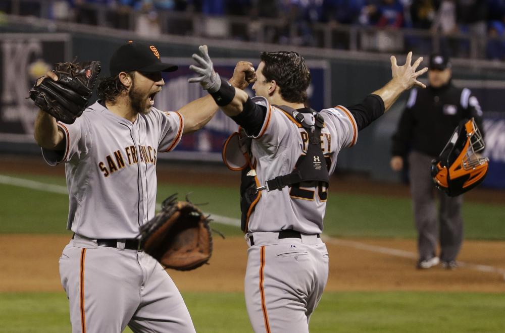 In this Oct. 29 file photo, San Francisco Giants pitcher Madison Bumgarner, left, and Buster Posey celebrate after winning 3-2 to win the series over Kansas City Royals after Game 7 of baseball’s World Series in Kansas City, Mo.