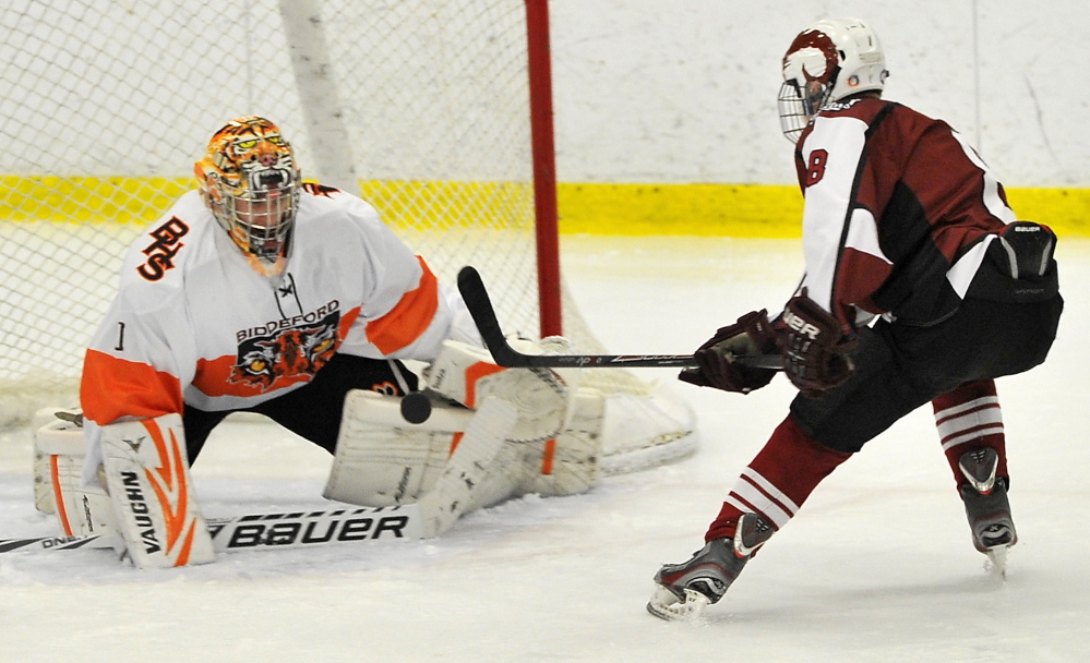 Biddeford goalie Brandon Daigle saves a breakaway by Bangor’s Nick Graham in their game Tuesday at Biddeford Ice Arena. Bangor dominated from the start, outshooting the Tigers 37-13, 26-5 over the final two periods.