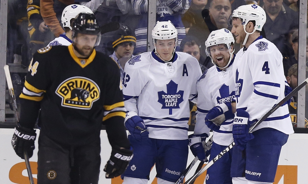 Toronto’s Phil Kessel (81) celebrates his goal with teammates Tyler Bozak (42) and Cody Franson (4) as the Bruins’ Dennis Seidenberg skates away during the second period of Wednesday night’s game in Boston. The Bruins tied the game with two goals late in the second period, but lost in an overtime shootout.