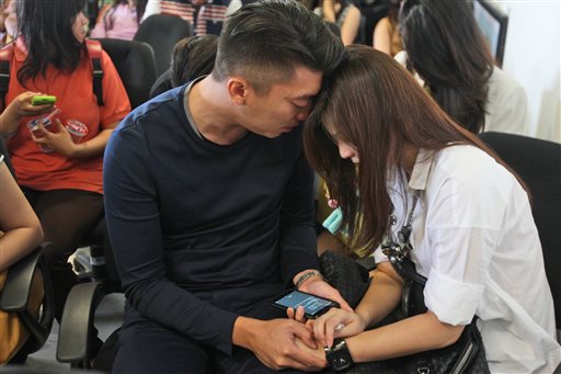 Relatives of the passengers of AirAsia flight QZ8501 comfort each other at Juanda International Airport in Surabaya, East Java, Indonesia, on Sunday. The Associated Press
