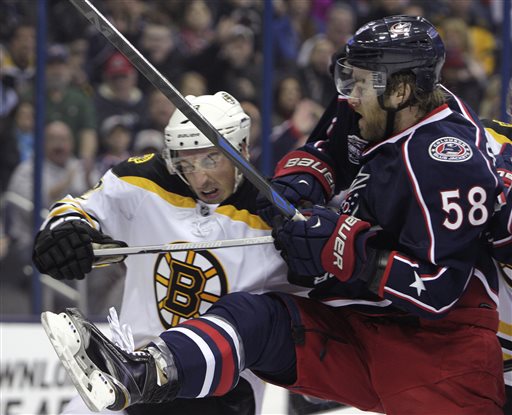 Boston Bruins' Brad Marchand, left, and Columbus Blue Jackets' David Savard fight for position in front of the net during the first period Saturday in Columbus, Ohio. The Associated Press